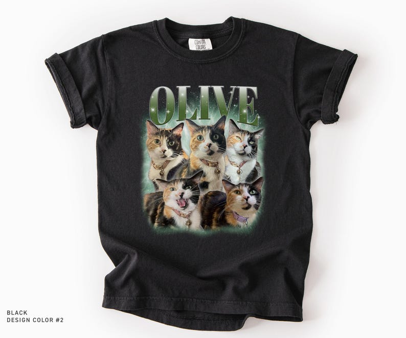 May include: A black short-sleeve t-shirt featuring a graphic print of five calico cats arranged in a cluster. Above the cats, the word OLIVE is printed in a large, bold, green-tinted font. The cats wear various collars with small charms.