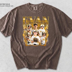 May include: Espresso-colored t-shirt featuring a baseball team photo with the name "EVAN" in gold lettering. The design includes a team photo with lightning bolt accents. The shirt has a crew neck and short sleeves.