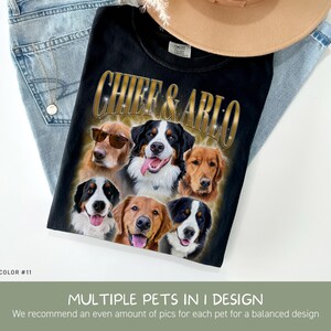 May include: A black t-shirt featuring a graphic print with the text CHIEF & ARLO in gold lettering above six dog portraits. The dogs include golden retrievers and Bernese mountain dogs, with one dog wearing sunglasses. The shirt is folded on blue jeans.