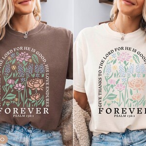 May include: Two t-shirts, one espresso and one ivory, featuring a floral design with the text "GIVE THANKS TO THE LORD FOR HE IS GOOD, HIS LOVE ENDURES, FOREVER, PSALM 136:1". The design includes pink, blue, and green flowers.