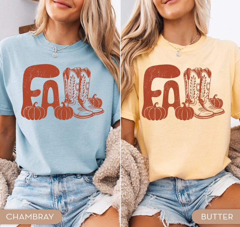 May include: Two short-sleeved t-shirts, one light blue and one yellow, each with a distressed orange graphic. The graphic says "FALL" with pumpkins and cowboy boots. The bottom of the shirts are visible.