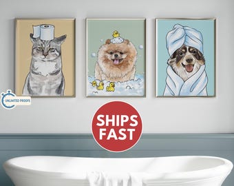 May include: Three framed art prints featuring animals in a bathroom setting. The first shows a cat with a toilet paper roll on its head. The second depicts a dog in a bubble bath with rubber duckies. The third shows a dog wrapped in a towel.