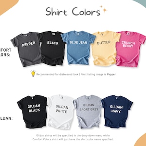 May include: A color chart displaying nine short-sleeve t-shirts arranged in two rows. The top row labeled Comfort Colors includes Pepper, Black, Blue Jean, Butter, and Crunch Berry. The bottom row labeled Gildan includes Black, White, Sport Grey, and Navy.