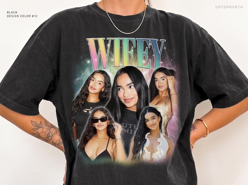 May include: A black crewneck t-shirt featuring a large graphic print with the word WIFEY in a rainbow gradient font. The design includes a collage of five photographs of the same person, set against a nebula-like background with stars.