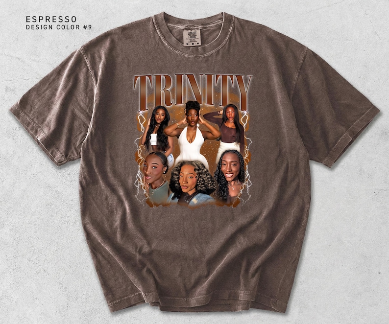 May include: Espresso-colored t-shirt with a graphic featuring the word "TRINITY" in a vintage font. The graphic includes images of six women. The shirt has a crew neck and short sleeves. The design color is #9.