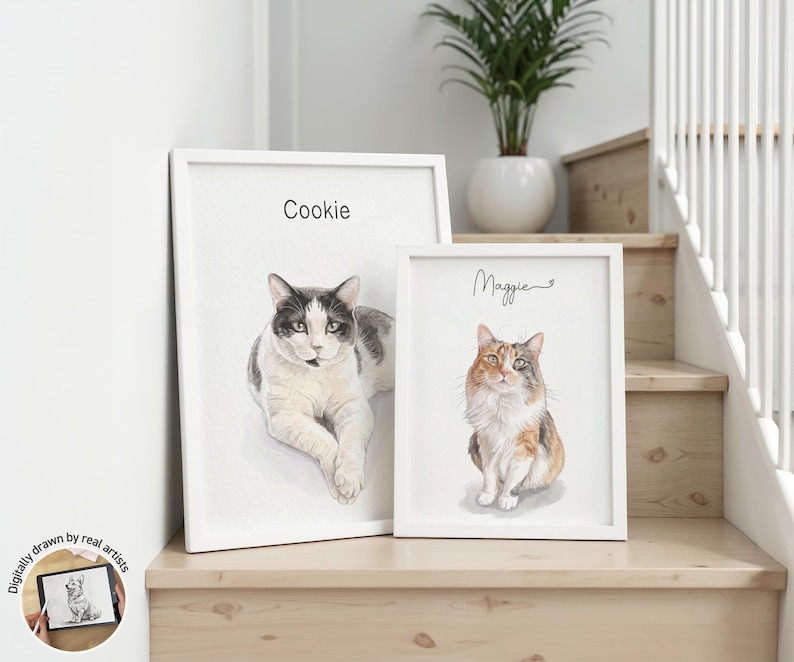 Op de afbeelding: Twee wit ingelijste wandkunstprints met aquarel-stijl portretten van katten. De grotere print toont een zwart-witte kat met het label Cookie, terwijl de kleinere print een lapjeskat toont met het label Maggie in cursief geschreven tekst.