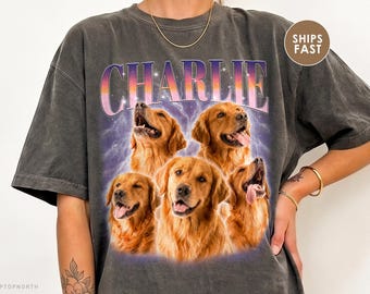 Puede incluir: Una camiseta gris carbón de manga corta con un estampado gráfico de cinco perros golden retriever. El nombre CHARLIE está impreso en letras grandes con degradado morado y naranja sobre los perros, con un fondo de rayos morados.