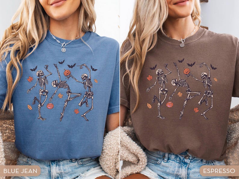 K&ouml;nnte beinhalten: Ein blaues Jeans-T-Shirt und ein espressobraunes T-Shirt, beide mit einem Grafikdruck von drei tanzenden Skeletten, orangefarbenen K&uuml;rbissen, schwarzen Flederm&auml;usen und verstreuten herbstlichen Bl&auml;ttern in Orange und Gelb auf der Brust.