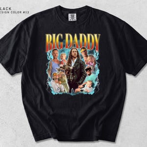 K&ouml;nnte beinhalten: Schwarzes T-Shirt mit einem Grafikdesign mit dem Text "BIG DADDY" in Orange und Gelb, mit einer Collage von Bildern. Das Design hat eine Retro-&Auml;sthetik mit Blitzakzenten.