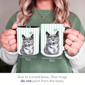 May include: Two white ceramic mugs with a light green vertical striped pattern and a gray cat illustration labeled Loki. The left mug is marked 11oz and the right mug is marked 15oz. Text below states: Due to curved base, 15oz mugs do not print from the base.