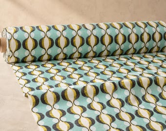 May include: A roll of fabric featuring a repeating pattern of vertical, interconnected oval shapes in shades of olive green, dark charcoal, and white, set against a light turquoise background. The textile is displayed as a partially unrolled bolt.