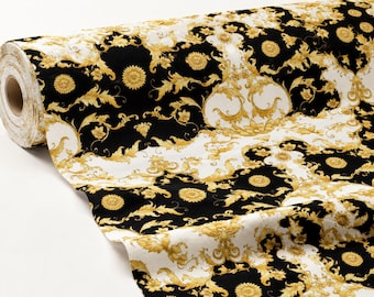 May include: A roll of fabric featuring a repeating pattern of gold acanthus leaves and circular floral medallions set against alternating black and white backgrounds. The textile displays a high-contrast design with intricate scrolling foliage motifs.