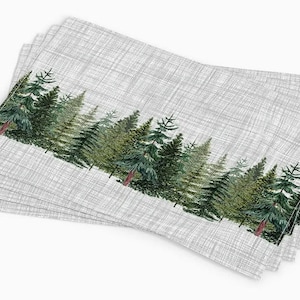 May include: Set of four gray linen placemats with a green watercolor forest print along the bottom edge.