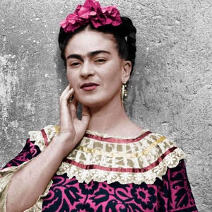 May include: A portrait of a person with dark hair, wearing a pink floral headpiece and gold earrings. The person is wearing a patterned dress with a ruffled collar. The background is a textured gray wall.