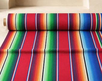 Könnte beinhalten: Eine Stoffrolle mit einem lebendigen, vom Serape inspirierten Muster mit vertikalen Streifen in leuchtendem Rot, Grün, Blau, Orange und Gelb, akzentuiert durch dünne weiße und schwarze Linien. Das Textil ist fest auf einen Pappkern gewickelt.