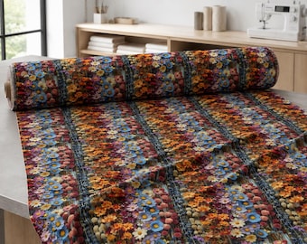 May include: A roll of fabric featuring a dense, repeating pattern of wildflowers in shades of orange, yellow, blue, and purple. The floral design is organized into vertical bands separated by dark, textured stripes that run across the length.