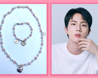 Può includere: Un set di collana e braccialetto con perline rosa e argento con ciondoli a forma di cuore. I ciondoli sono incisi con la parola "Mommy".
