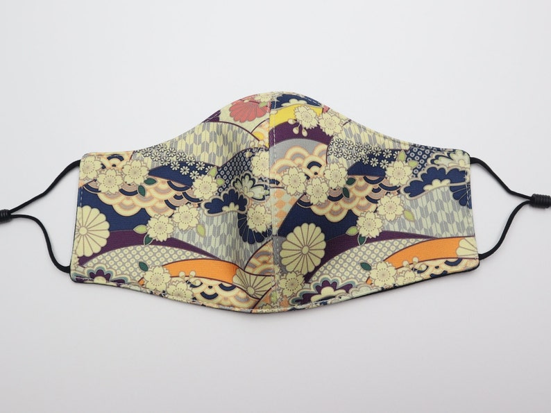 May include: A face mask with a colorful Japanese-inspired pattern featuring flowers, waves, and geometric designs in shades of blue, purple, orange, and yellow.