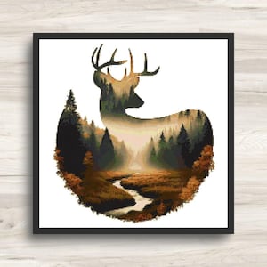May include: A square cross-stitch pattern featuring the silhouette of a deer filled with a landscape scene. The image depicts a winding river flowing through a dense forest with dark green pine trees and golden-brown autumn foliage.