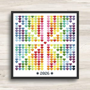 May include: A square cross-stitch pattern featuring a grid of small, multi-colored hearts arranged in four quadrants around a single central heart. The colors include shades of red, orange, yellow, green, blue, purple, and pink. The text 2026 is centered at the bottom.