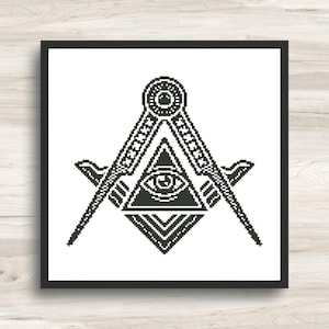May include: Black and white cross-stitch design featuring the Masonic Square and Compasses symbol, with an all-seeing eye within a triangle. The artwork is framed in a black square.