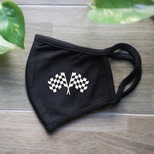 May include: Black face mask with a white checkered flag design.
