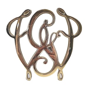 May include: A gold-coloured metal monogram featuring the intertwined letters "C & W" in a decorative, flowing script. The design has rounded edges and a symmetrical shape, suitable for jewellery or decorative items.