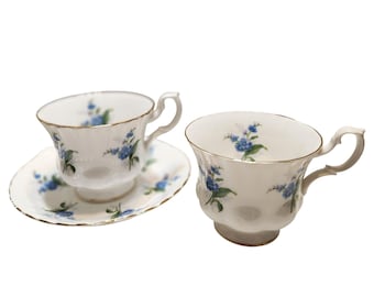 Tazas y platillos de porcelana fina Royal Albert vintage con estampado floral azul y borde dorado.