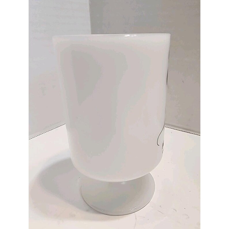 Puede incluir: Una copa de vidrio blanco opaco con un cuenco redondeado y una base corta y circular. La copa tiene una superficie lisa y un dise&ntilde;o simple y elegante. El vidrio es grueso y parece resistente.
