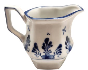 Jarra de crema de porcelana vintage azul y blanca con estampado floral y asa. LEER