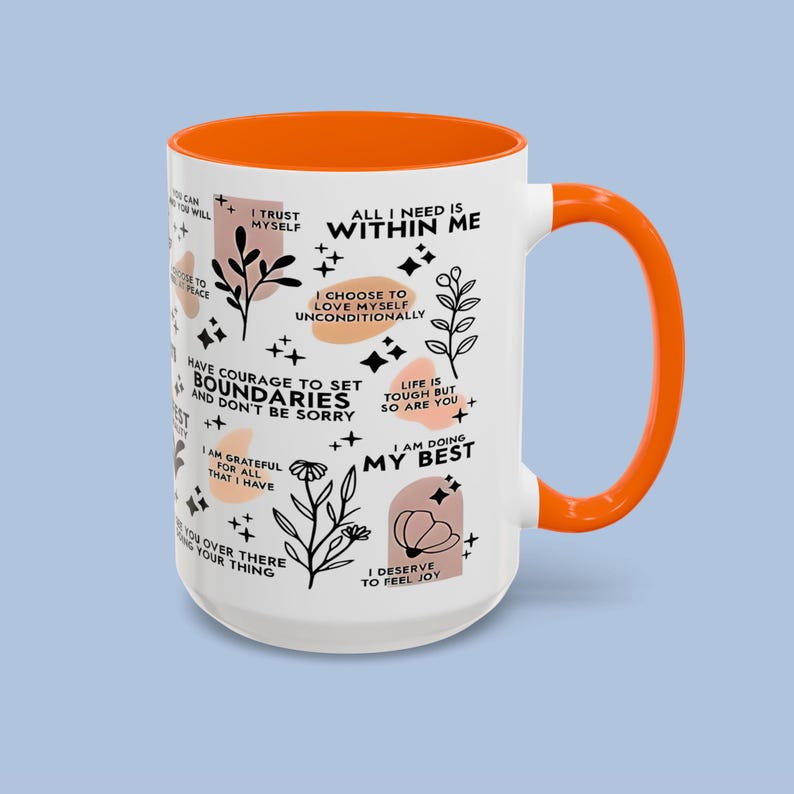 Puede incluir: Taza de cer&aacute;mica blanca con interior y asa naranja. La taza presenta frases inspiradoras e ilustraciones bot&aacute;nicas en negro y rosa. El texto incluye "Todo lo que necesito est&aacute; dentro de m&iacute;" y "Estoy haciendo lo mejor que puedo."