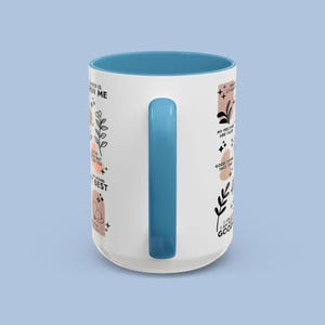 Puede incluir: Taza de cer&aacute;mica blanca con interior y asa azules. La taza presenta citas inspiradoras e ilustraciones bot&aacute;nicas en negro, rosa y melocot&oacute;n. Un regalo perfecto para cualquiera que disfrute de una dosis diaria de positividad.