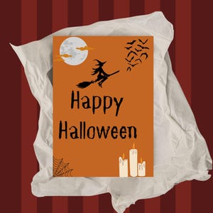Peut inclure: Une carte de vœux rectangulaire orange avec une silhouette noire de sorcière volant sur un balai, une pleine lune, une nuée de chauves-souris, une toile d'araignée et trois bougies blanches. Le texte Happy Halloween est imprimé en noir.