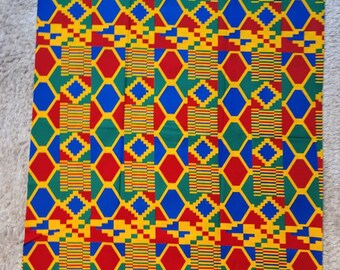 Può includere: Un tessuto colorato con un motivo geometrico in tonalità di rosso, giallo, blu e verde. Il motivo è composto da esagoni e quadrati.