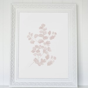 May include: A white frame with a delicate, ornate design surrounds a print of a pale pink fern on a white background.