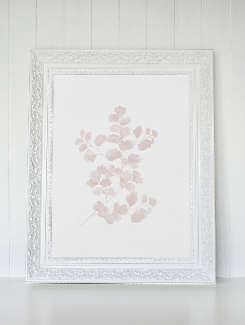 May include: A white frame with a delicate, ornate design surrounds a print of a pale pink fern on a white background.
