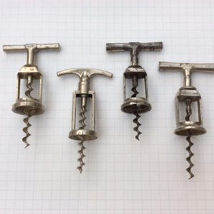 Puede incluir: Cuatro sacacorchos plateados con diferentes diseños de mango. Cada sacacorchos tiene un gusano de metal en espiral para abrir botellas de vino.