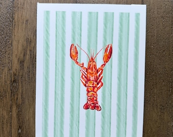 May include: A watercolor painting of a red lobster with orange accents, set against a backdrop of vertical green and white stripes. The artwork is signed "ALE" in the bottom right corner. The painting is on a white rectangular canvas.
