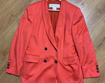 May include: A coral colored double-breasted blazer with gold buttons. The blazer has a shawl collar and two pockets.