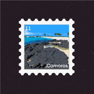 May include: A postage stamp with a blue sky, white sand beach, and black volcanic rocks. The stamp says "Comoros" and "11" in the top left corner.