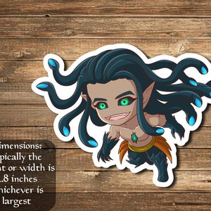 May include: A sticker featuring a cartoon illustration of a green-haired, snake-haired creature with blue eyes and a mischievous grin. The creature is wearing a gold belt and a green gem around its neck. The sticker is approximately 2.8 inches in size.