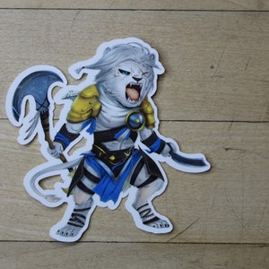 May include: A white lion-like creature with a blue and gold outfit, holding a curved axe and a dagger. The creature has a fierce expression and is depicted in a fighting pose.