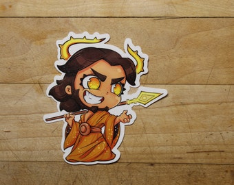May include: A cartoon illustration of a person with brown hair and a golden halo, wearing a gold robe and holding a spear. The person has a mischievous expression with glowing yellow eyes.