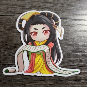 May include: A sticker featuring a cartoon character with long black hair, wearing a red and yellow robe, holding a scroll with green writing. The character has red eyes and a serious expression.