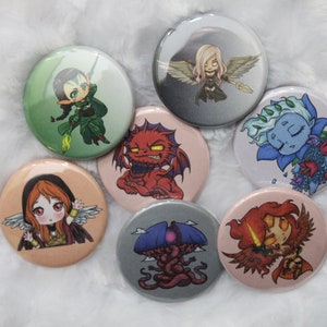 May include: Seven round buttons with different cartoon characters. The buttons are white with a black outline and feature various characters, including a red dragon, a blue fairy, a green elf, a red-haired angel, a purple creature, and a pink-haired angel.