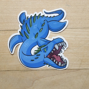 May include: A blue and green cartoon sticker of a sea monster with sharp teeth and spines. The monster is curled up with its tail in its mouth.