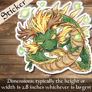 Puede incluir: Una pegatina de dragón verde y dorado con cuernos, enroscado en un círculo con llamas verdes brillantes. La pegatina está sobre un fondo de madera.