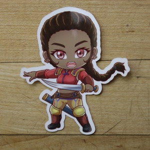 May include: A cartoon sticker of a female warrior with brown skin, wearing a red and gold outfit, holding a sword and a dagger. She has a braid in her hair and is looking determined.