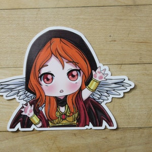 Puede incluir: Una pegatina de dibujos animados de una niña con cabello naranja, que lleva una capa con capucha negra y una capa roja, con alas blancas y una pieza de pecho dorada. Tiene una expresión de sorpresa y está saludando con una mano.