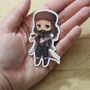 May include: A cartoon sticker of a person wearing a brown hat and a white coat, holding a gun and a knife. The person has a beard and is looking to the right.